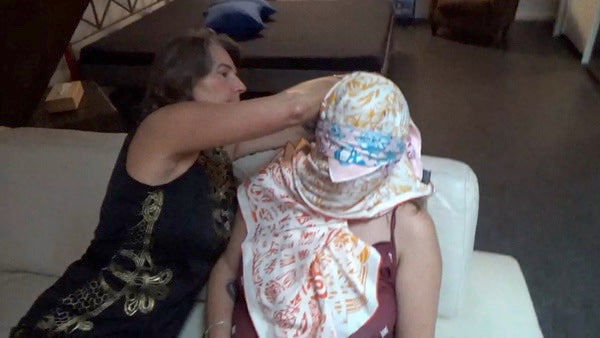 2 ladies are playing around with silk scarves